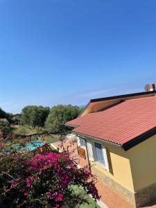um edifício com um telhado vermelho e algumas flores em Villa Karillos - b50282 em Marina di Camerota