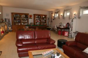 a living room with a leather couch and a table at La Closerie des Sacres in Lavannes