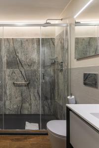 La salle de bains est pourvue d'une douche en verre, de toilettes et d'un lavabo. dans l'établissement MyItalyHome Roma, à Rome