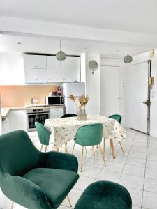 ein Esszimmer mit einem Tisch und grünen Stühlen in der Unterkunft Appartement face gare / centre in Argenteuil + 23 Fotos