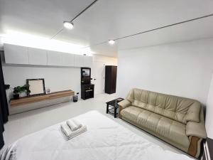 uma sala de estar com um sofá e uma mesa em Impact-Don Mueang Bangkok Popular Condo C4 em Pak Kret