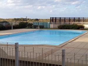een groot blauw zwembad met een standbeeld erin bij charmant appartement port de Dives sur mer in Dives-sur-Mer