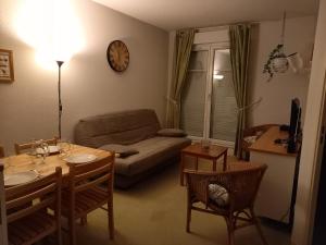 een woonkamer met een bank en een tafel bij charmant appartement port de Dives sur mer in Dives-sur-Mer