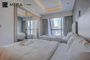 ドバイにあるMira Holiday Homes - Fully furnished 1 bedroom in Paramountのベッド2台と大きな窓が備わるホテルルームです。