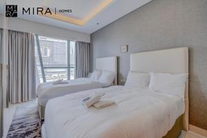2 camas en una habitación de hotel con ventana en Mira Holiday Homes - Fully furnished 1 bedroom in Paramount en Dubái