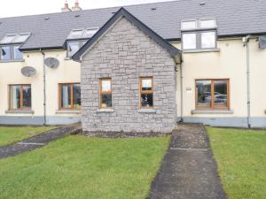 a house with windows and a grass yard at Sea Breeze Holiday Home in Enniscrone