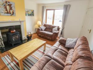 a living room with a couch and a fireplace at Sea Breeze Holiday Home in Enniscrone