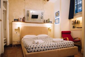 een slaapkamer met een bed met een spiegel en een rode stoel bij Happy Navona in Rome