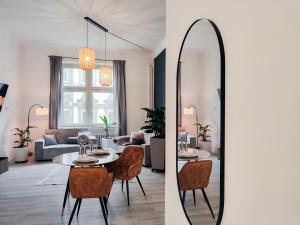 een woonkamer met een spiegel en een tafel en stoelen bij o Loft Studio I 50qm I zentral & ruhig I Messe HBF nah in Essen