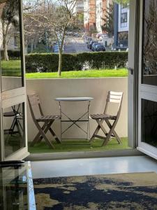 two chairs and a table on a porch with a window at T2 proche du centre ville in Toulouse