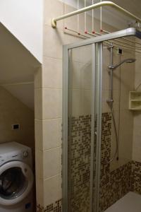uma casa de banho com um chuveiro, um WC e uma cabina de duche em vidro. em Casa Marina - Holiday Rental em Garda
