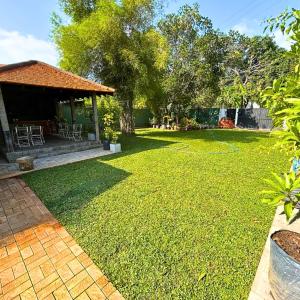 a yard with a house with a grass lawn at The Ivy Lake in Anuradhapura