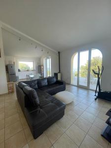 uma sala de estar com um sofá de couro preto e uma mesa em Villa Karillos - b50282 em Marina di Camerota