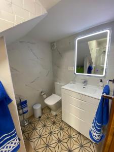 a bathroom with a sink and a toilet and a mirror at Casa El Capitán in Málaga