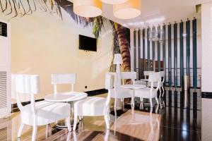 uma sala de jantar com cadeiras brancas e uma mesa em Beira Terrace Hotel na Beira