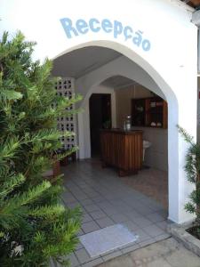 an entrance to a house with an archway and a table at Pousada dos Arcos e Condomínio in Conde