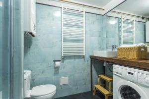 y baño con lavamanos y lavadora. en Mieszkanie w centrum, en Poznan
