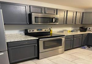 a kitchen with stainless steel appliances and black cabinets at Two Bed Apartment In Mid West in New York