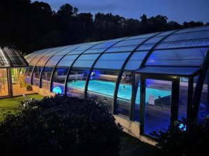 ein Glashaus mit Swimmingpool in der Nacht in der Unterkunft Bungalow 3 étoiles - Piscine - eehheh in Landry