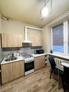 a kitchen with a stove and a sink and a table at Apartment Kyiv in Kyiv