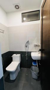 a bathroom with a toilet and a sink at Ayur Arogyam Rooms and Spa in Kondotti