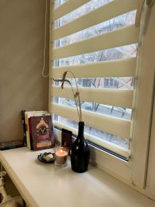 a candle and a vase sitting on a window sill at Apartment Kyiv in Kyiv