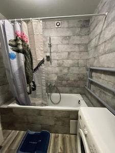 a bathroom with a crocodile shower curtain and a tub at Apartment Kyiv in Kyiv