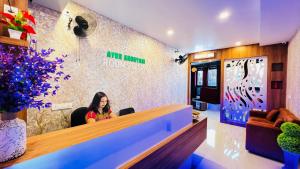 a woman sitting at a reception desk in a room at Ayur Arogyam Rooms and Spa in Kondotti