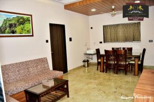 sala de estar con sofá, mesa y sillas en Sahyadri Stud Farm & Resort, en Mahabaleshwar
