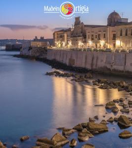 a view of a river in a city at night at Made in Ortigia Apartments in Siracusa
