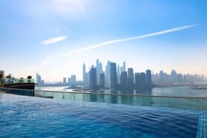 een zwembad met uitzicht op de skyline van de stad bij Modern 1 bedroom at Palm Jumeirah in Dubai