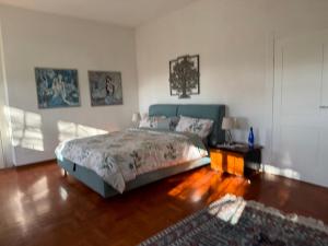 a bedroom with a bed and a wooden floor at VILLA TARA in Quercianella