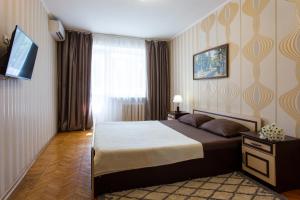 a bedroom with a large bed and a television at Botanical garden area in Kharkiv