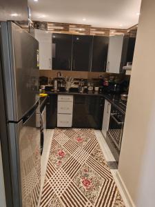 een keuken met een koelkast en een tegelvloer bij شقة فندقية بحر مباشر in Alexandrië