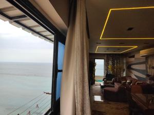 een woonkamer met uitzicht op de oceaan vanuit een bus bij شقة فندقية بحر مباشر in Alexandrië