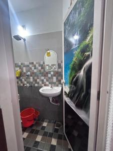 a bathroom with a sink and a painting on the wall at Chaithritha Ladies Only Homestay in Trivandrum