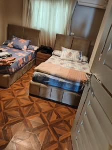 twee bedden in een kamer met een deur open bij شقة فندقية بحر مباشر in Alexandrië