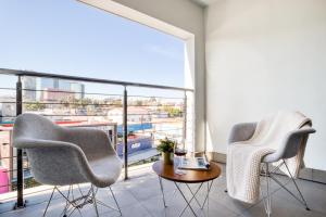 two chairs and a table in a room with a large window at Eazy Rio by ULIV in Tijuana