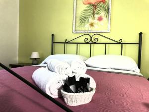 Una cama con toallas y una cesta de toallas. en CLUB HOUSE - ASD Sacramento Golf en Sabaudia