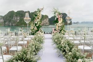 Un pasillo de bodas con sillas blancas y flores en Essence Grand Halong Bay Cruise 1 en Ha Long