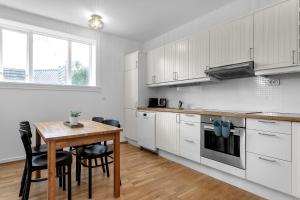 een keuken met witte kasten en een houten tafel bij Eiriksgata Apartments by Heimaleiga in Reykjavík +56 foto's