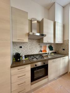 cocina con armarios blancos y fogones en Dama apartment in Como city center en Como
