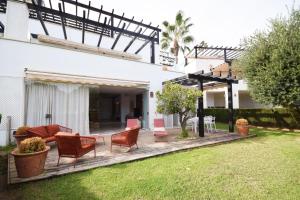 a deck with chairs and a couch on a yard at Las Terrazas de Santa Clara in Marbella