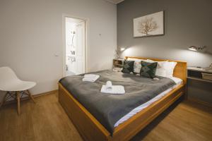 a bedroom with a bed with two towels on it at Bearsleys Downtown Apartments in Rīga