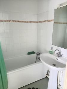 een badkamer met een wastafel, een bad en een wastafel bij charmant appartement port de Dives sur mer in Dives-sur-Mer