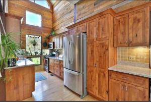 a kitchen with wooden cabinets and a stainless steel refrigerator at MapleCastle == HotTub, RiverSide, IndoorHummock, FirePlace, BackYard 
