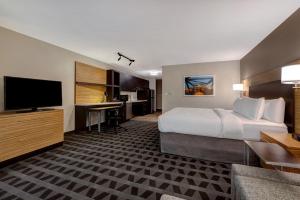 a hotel room with a bed and a flat screen tv at Courtyard St. Louis Brentwood in Richmond Heights