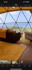 uma sala de estar com um sofá e uma grande janela em Geodome with sea views near Pendine em Pendine