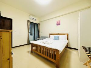 1 dormitorio con 1 cama y TV en 新竹比斯 Hsinchu Peace en Zhubei