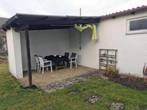 een patio met een tafel en stoelen onder een pergola bij 3 Zimmer Ferienwohnung mit eigenem Garten Trossingen in Trossingen